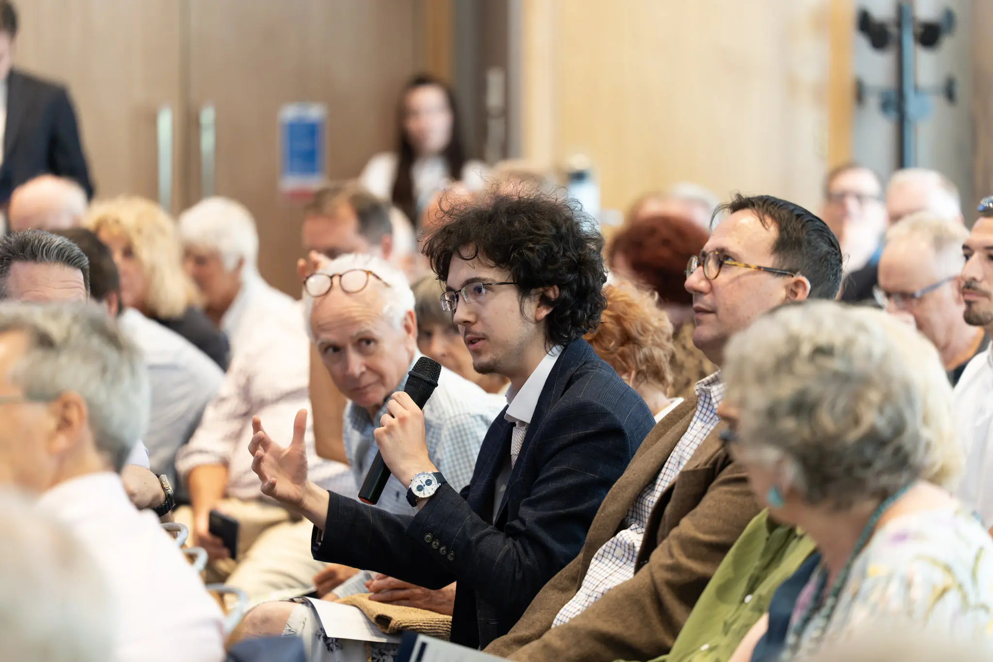 Delegates in conversation in the auditorium during a Heterodox Conference session